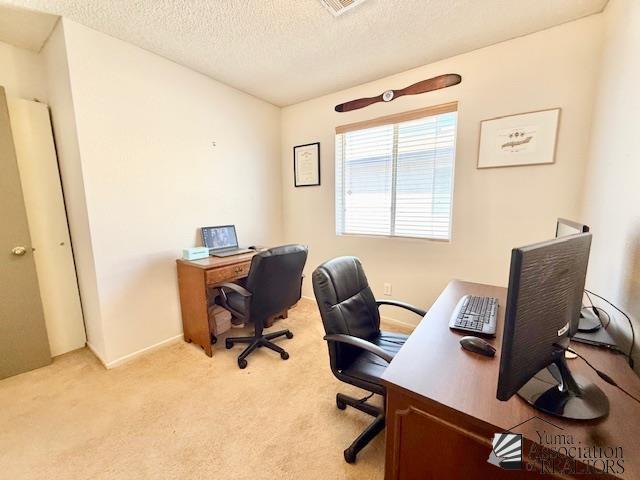 office area with light colored carpet and a textured ceiling