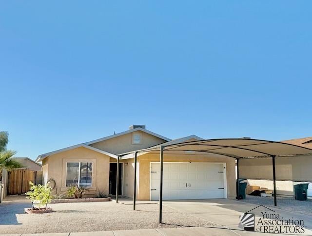 view of front facade with stucco siding, driveway, a garage, and fence