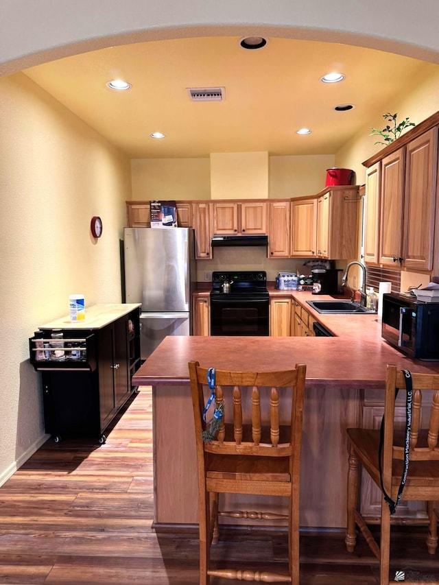 14453 E 55th St, Yuma, AZ 85367 - kitchen featuring a sink, light wood-style flooring, a peninsula, under cabinet range hood, and black appliances