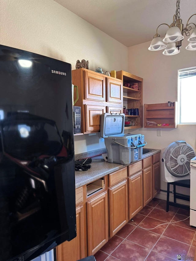 14453 E 55th St, Yuma, AZ 85367 - kitchen with brown cabinetry, hanging light fixtures, open shelves, dark tile patterned flooring, and an inviting chandelier