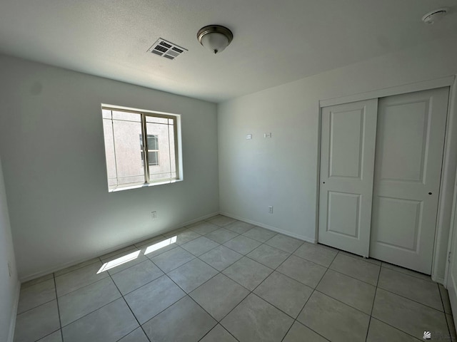 10744 E 45th Pl, Yuma, AZ 85367 - unfurnished bedroom featuring light tile patterned flooring, a closet, and baseboards