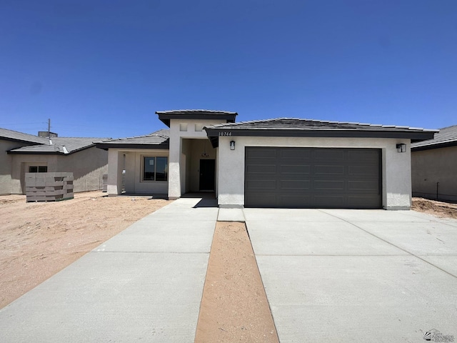 10744 E 45th Pl, Yuma, AZ 85367 - prairie-style house with concrete driveway, stucco siding, a garage, and a tiled roof