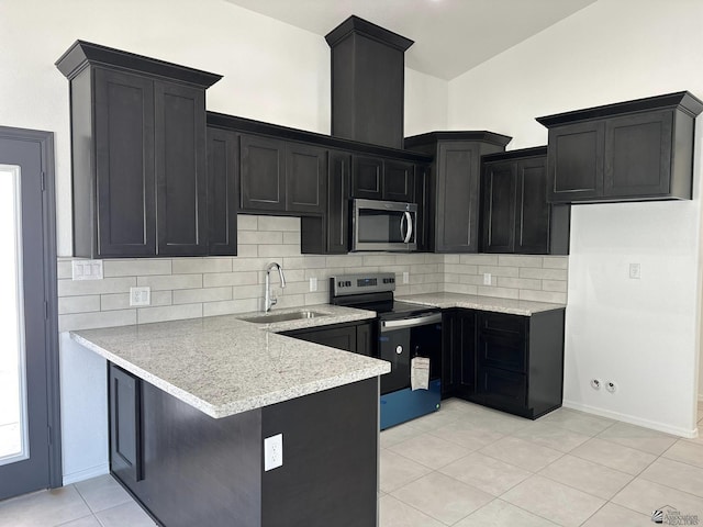 10744 E 45th Pl, Yuma, AZ 85367 - kitchen with a sink, stainless steel appliances, a peninsula, dark cabinetry, and backsplash