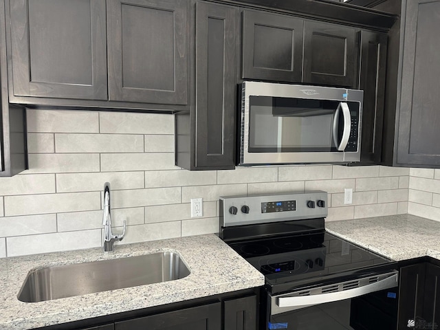 10744 E 45th Pl, Yuma, AZ 85367 - kitchen with appliances with stainless steel finishes, a sink, backsplash, and light stone countertops