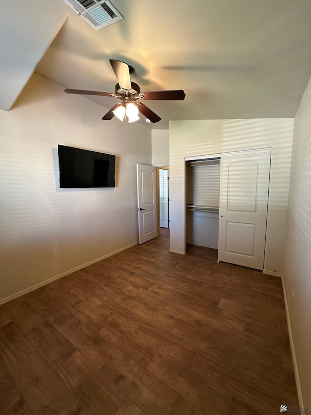 unfurnished bedroom with ceiling fan and dark wood-type flooring