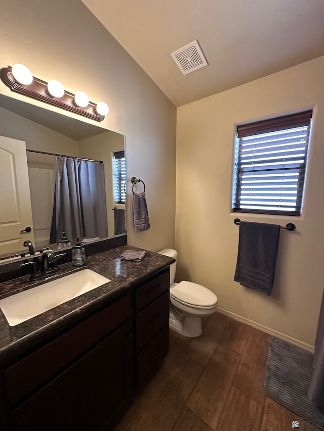 bathroom with a shower with shower curtain, vanity, wood-type flooring, and toilet