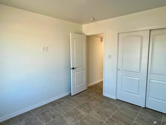 29861 E Vista Ridge Blvd, Wellton, AZ 85356 - unfurnished bedroom featuring baseboards, a closet, and dark tile patterned floors