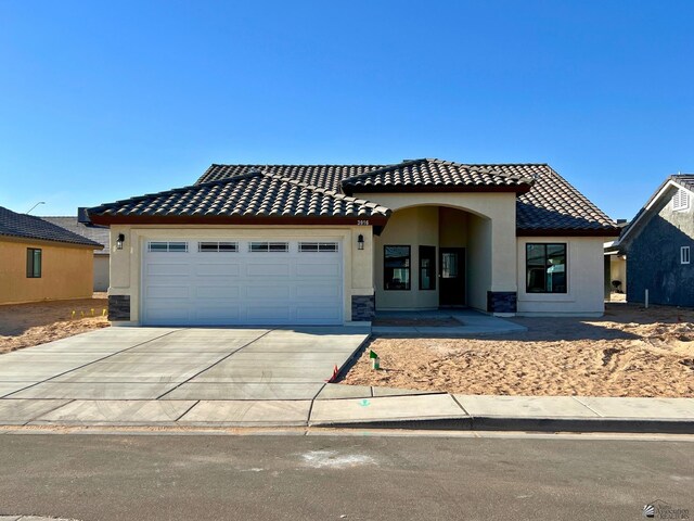 29861 E Vista Ridge Blvd, Wellton, AZ 85356 - view of front of home with an attached garage, a tiled roof, concrete driveway, and stucco siding