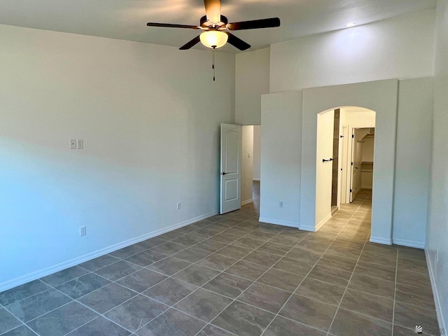 29861 E Vista Ridge Blvd, Wellton, AZ 85356 - unfurnished bedroom with a towering ceiling, baseboards, ceiling fan, dark tile patterned floors, and arched walkways