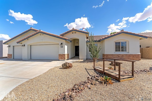 11637 E 27th St, Yuma, AZ 85367 - mediterranean / spanish house featuring concrete driveway, an attached garage, stone siding, and stucco siding