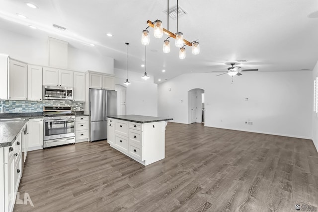 11637 E 27th St, Yuma, AZ 85367 - kitchen with decorative backsplash, a ceiling fan, dark countertops, appliances with stainless steel finishes, and arched walkways