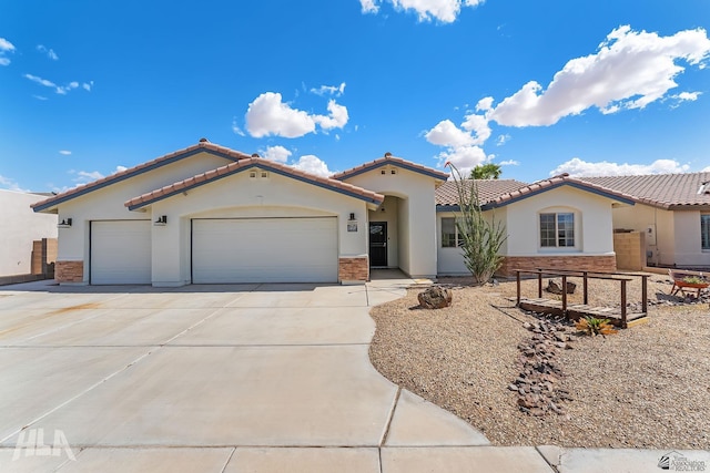 11637 E 27th St, Yuma, AZ 85367 - mediterranean / spanish-style house featuring concrete driveway, stucco siding, an attached garage, and stone siding