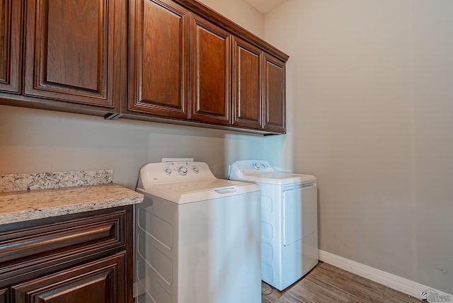 14769 E 47th Ln, Yuma, AZ 85367 - clothes washing area featuring cabinet space, separate washer and dryer, baseboards, and light wood-type flooring
