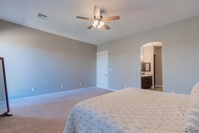 14769 E 47th Ln, Yuma, AZ 85367 - bedroom with arched walkways, carpet floors, baseboards, ensuite bath, and a ceiling fan