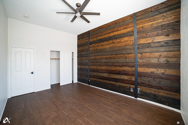 2864 W 12th Ln, Yuma, AZ 85364 - unfurnished bedroom featuring dark wood-type flooring, wood walls, a closet, and ceiling fan