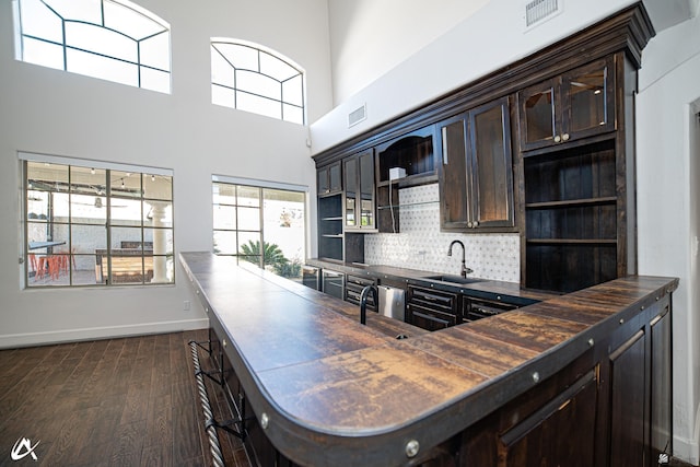 2864 W 12th Ln, Yuma, AZ 85364 - kitchen with open shelves, dark brown cabinets, dark wood-type flooring, decorative backsplash, and a towering ceiling
