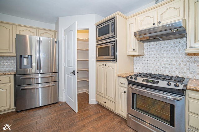 2864 W 12th Ln, Yuma, AZ 85364 - kitchen featuring cream cabinets, stainless steel appliances, under cabinet range hood, dark wood-style floors, and light stone counters