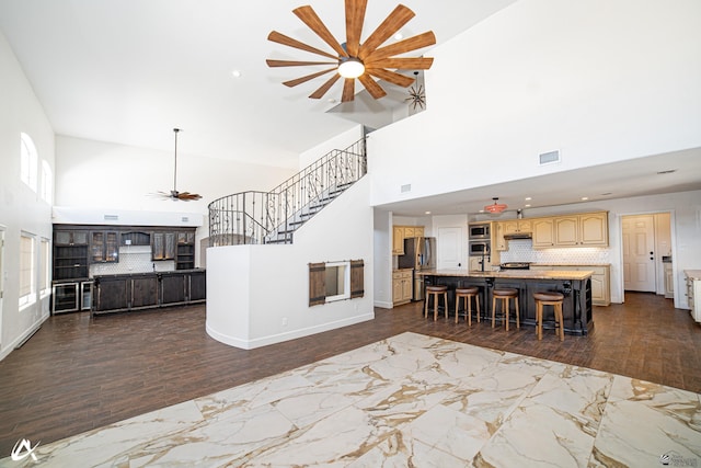 2864 W 12th Ln, Yuma, AZ 85364 - kitchen featuring ceiling fan, a high ceiling, open floor plan, dark wood-type flooring, and a kitchen breakfast bar