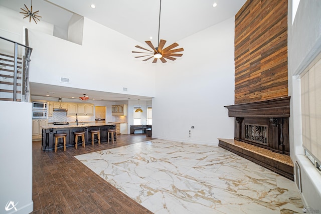 2864 W 12th Ln, Yuma, AZ 85364 - living room featuring a high ceiling, a fireplace with raised hearth, a ceiling fan, and recessed lighting
