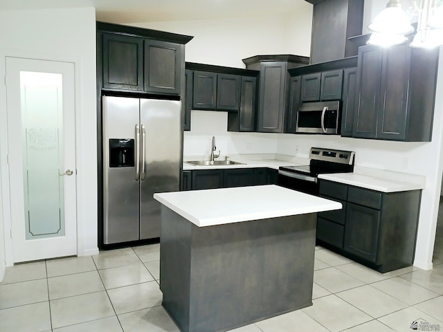 kitchen featuring a center island, a sink, light tile patterned floors, light countertops, and stainless steel appliances