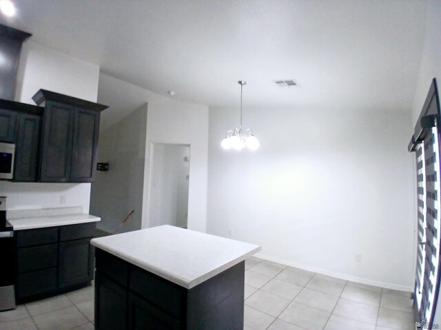 kitchen featuring a kitchen island, visible vents, light countertops, light tile patterned floors, and a chandelier