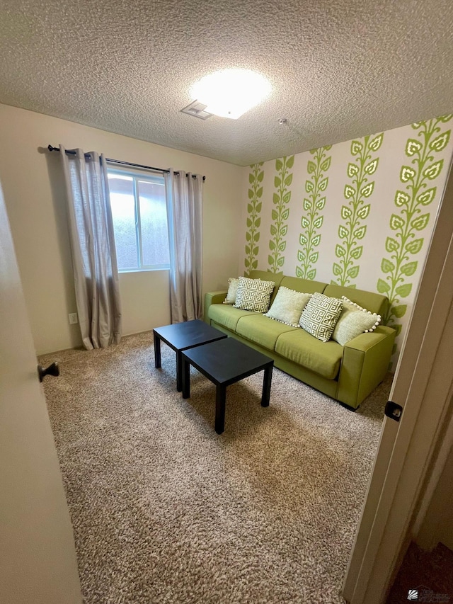 carpeted living area with visible vents and a textured ceiling