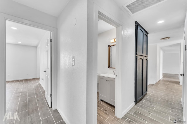 1721 S Athens Ave, Yuma, AZ 85364 - corridor featuring wood tiled floors, baseboards, a sink, and recessed lighting