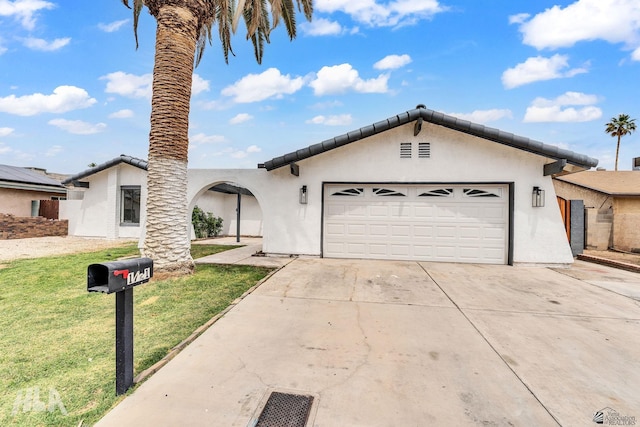 1721 S Athens Ave, Yuma, AZ 85364 - view of front of house with a front yard, an attached garage, concrete driveway, and stucco siding