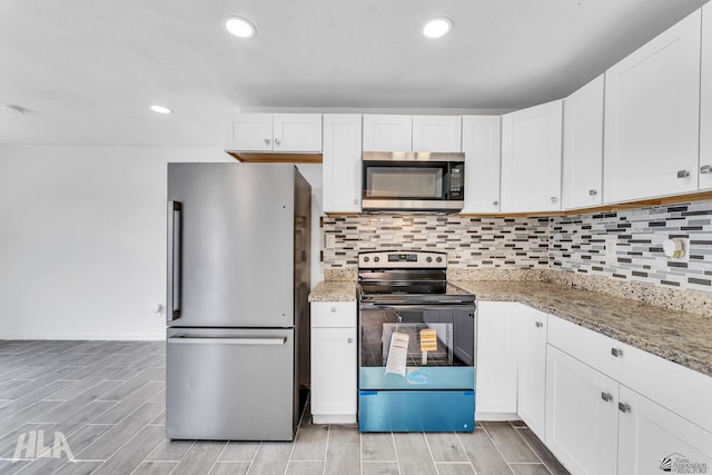 1721 S Athens Ave, Yuma, AZ 85364 - kitchen featuring appliances with stainless steel finishes, wood tiled floors, white cabinetry, tasteful backsplash, and light stone countertops