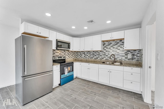 1721 S Athens Ave, Yuma, AZ 85364 - kitchen with appliances with stainless steel finishes, a sink, white cabinets, light stone counters, and backsplash