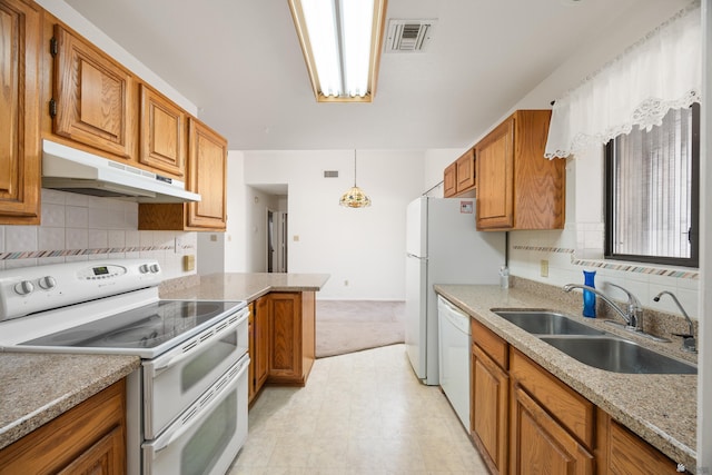 13239 E 47th Dr, Yuma, AZ 85367 - kitchen featuring white appliances, under cabinet range hood, brown cabinetry, and decorative backsplash