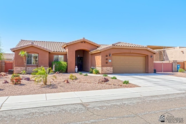 11861 E Eclipse Ct, Yuma, AZ 85367 - mediterranean / spanish house featuring an attached garage, stucco siding, and stone siding