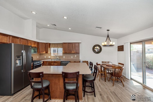 11861 E Eclipse Ct, Yuma, AZ 85367 - kitchen with visible vents, lofted ceiling, light countertops, a sink, and stainless steel appliances