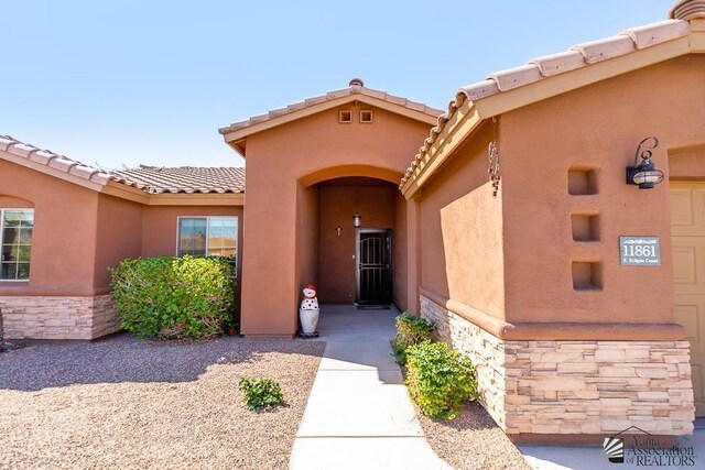 11861 E Eclipse Ct, Yuma, AZ 85367 - property entrance featuring stucco siding, a tiled roof, and stone siding