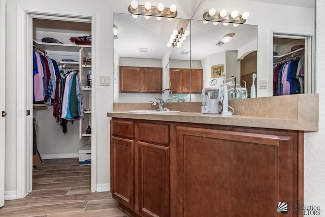 11861 E Eclipse Ct, Yuma, AZ 85367 - full bathroom featuring baseboards, vanity, wood finished floors, and a spacious closet