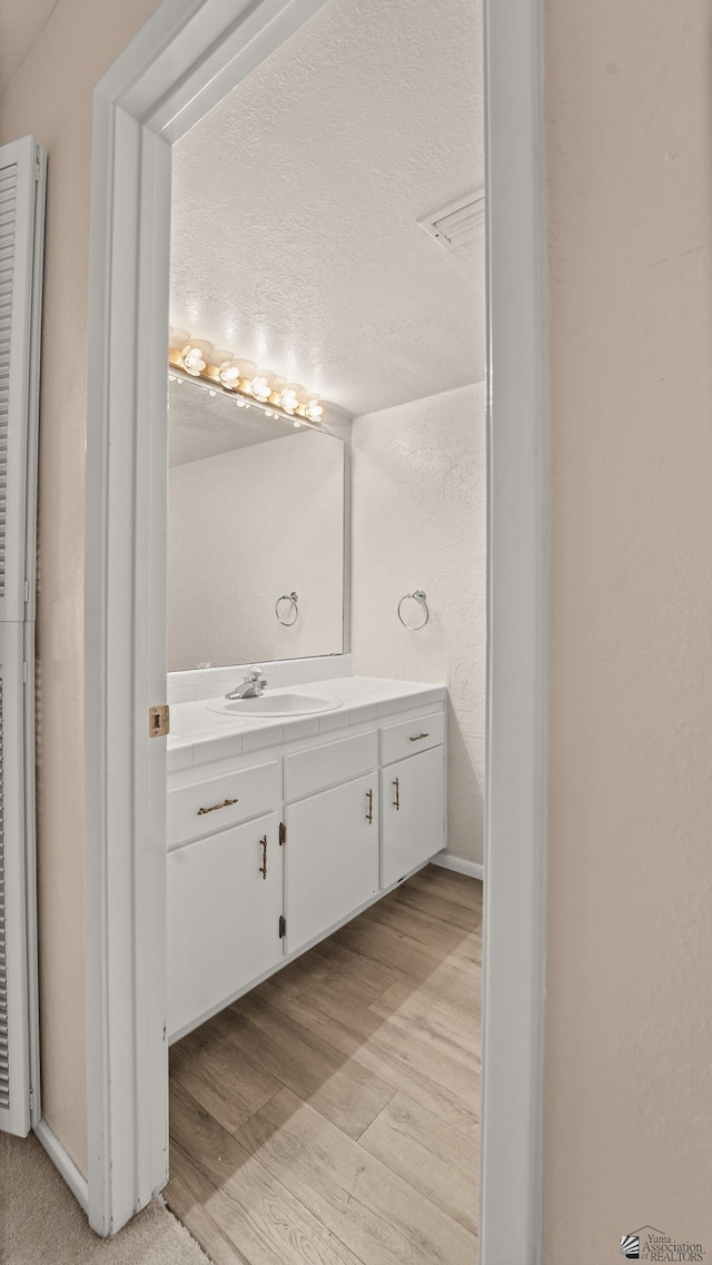 1440 E Laguna Pl, Yuma, AZ 85365 - bathroom featuring wood finished floors, vanity, and a textured wall