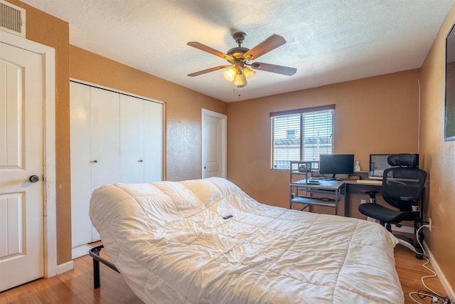 2931 W 20th St, Yuma, AZ 85364 - bedroom featuring wood finished floors, a closet, a textured ceiling, baseboards, and a ceiling fan