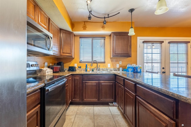 2931 W 20th St, Yuma, AZ 85364 - kitchen with stainless steel appliances, a sink, dark stone counters, light tile patterned floors, and pendant lighting