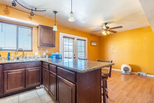 2931 W 20th St, Yuma, AZ 85364 - kitchen with a sink, a peninsula, ceiling fan, a kitchen breakfast bar, and baseboards