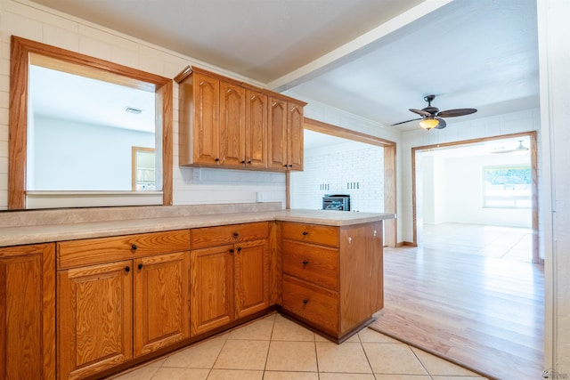 1257 W 18th St, Yuma, AZ 85364 - kitchen with light countertops, a peninsula, ceiling fan, brown cabinetry, and light tile patterned flooring
