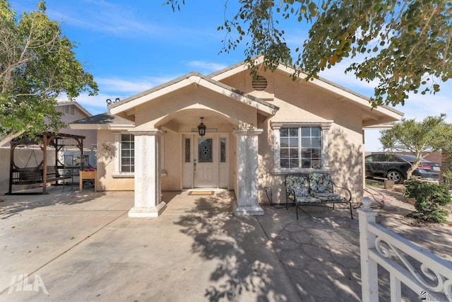 view of front of house featuring stucco siding and a patio