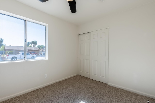 unfurnished bedroom featuring a closet, carpet, ceiling fan, and baseboards