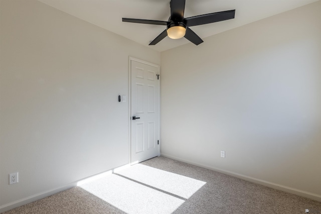 spare room featuring baseboards, a ceiling fan, and light colored carpet