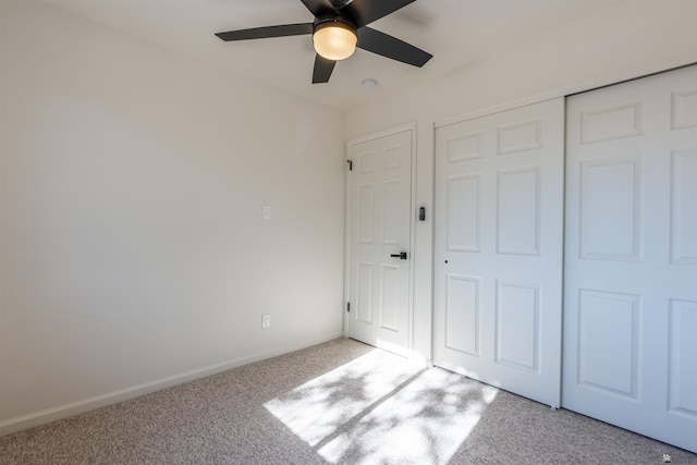 unfurnished bedroom with baseboards, a ceiling fan, carpet, and a closet
