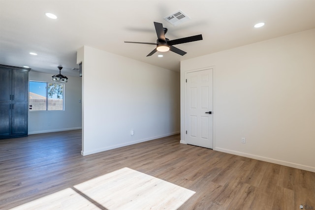 empty room featuring visible vents, baseboards, recessed lighting, light wood-type flooring, and a ceiling fan