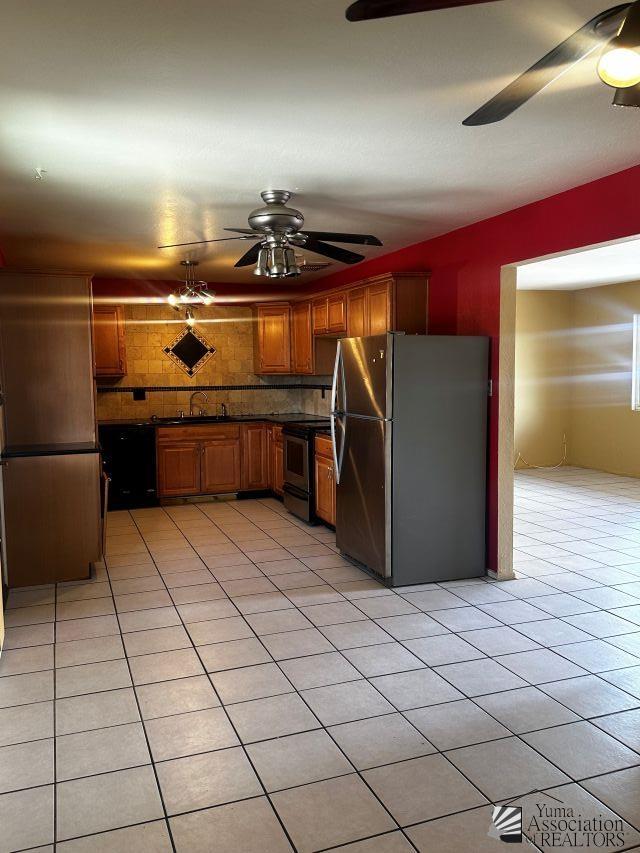 1527 E 23rd St, Yuma, AZ 85364 - kitchen featuring ceiling fan, brown cabinetry, decorative backsplash, appliances with stainless steel finishes, and light tile patterned floors
