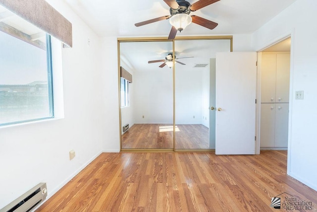 13125 E 51st Ln, Yuma, AZ 85367 - unfurnished bedroom with a closet, baseboards, ceiling fan, baseboard heating, and light wood-style flooring