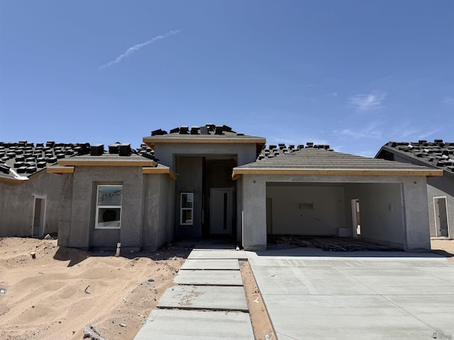 property under construction with a garage and concrete driveway