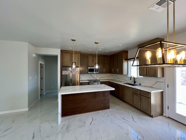 kitchen with stainless steel appliances, a sink, baseboards, a center island, and light stone counters
