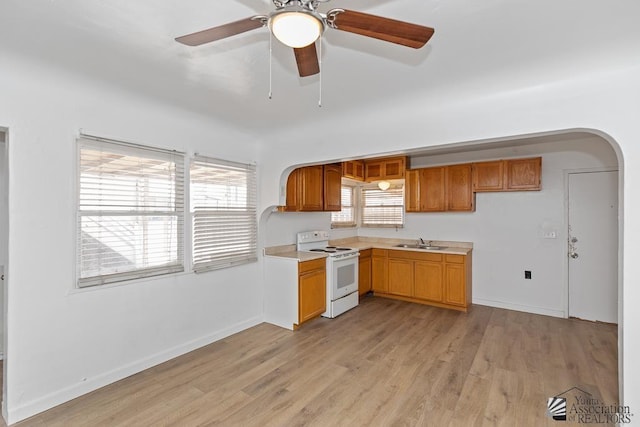 185 S 5th Ave, Yuma, AZ 85364 - kitchen featuring electric stove, arched walkways, a sink, and light wood-style floors